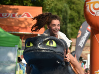 Ein lachendes Mädchen reitet auf einer Drachenfigur