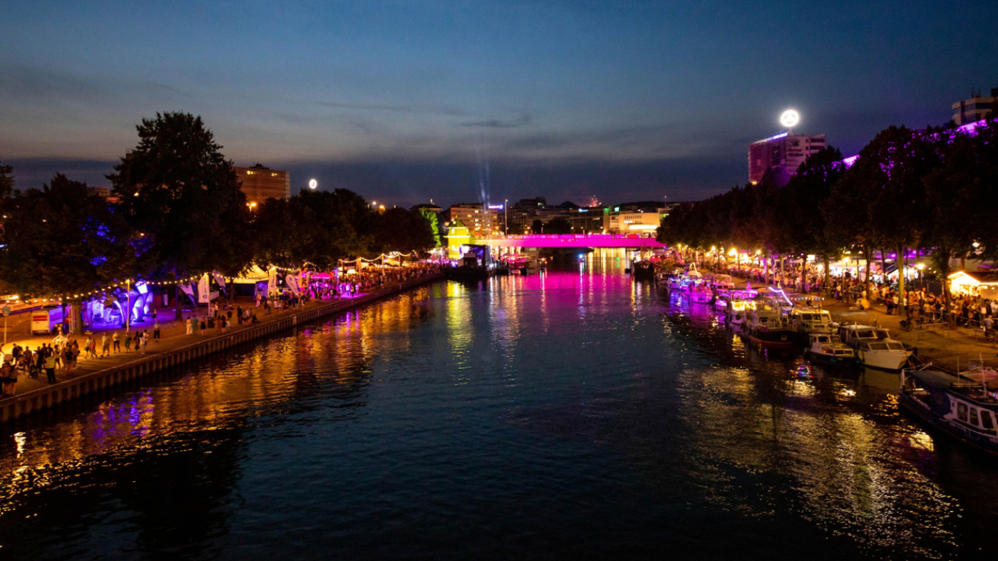 Blick auf bunt beleuchtet Wilhelm-Heinrich-Brücke während dem Saar-Spektakel, mit Publikum und Saarkran