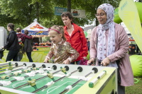 Eine Frau und ein Mädchen spielen lachend Tischfußball