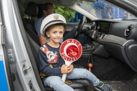 Halt, Polizei! Ein junger Besucher. Ein Junge mit Polizeimütze und Kelle