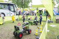 Ein abgegrenzter Bereich mit Spielzeug-Baufahrzeugen und spielenden Kindern