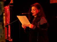 Jenny Theobald steht mit Skript in der Hand vor Mikrofon