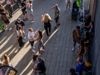 Mehrere Paare tanzen umgeben von Zuschauerinnen und Zuschauern.