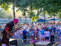 Blick von der Bühne: Ein Mann spielt Gitarre, vor der Bühne steht Publikum.